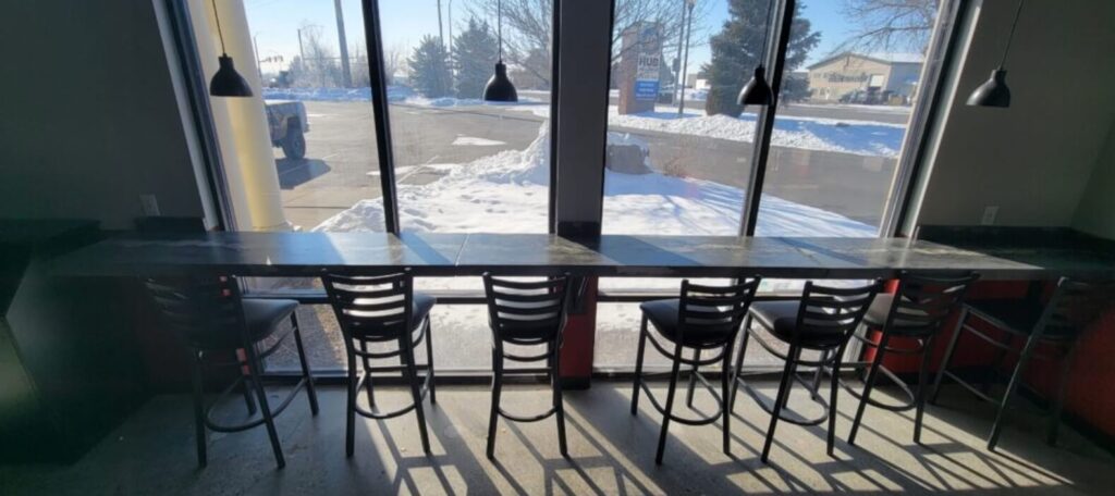 Custom long countertop made of concrete in front of large windows - KretworX in Idaho Falls.