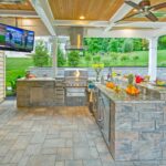 Large outdoor cooking area with stove vent and TV and ceiling fan - Idaho Falls outdoor kitchen KreteworX.